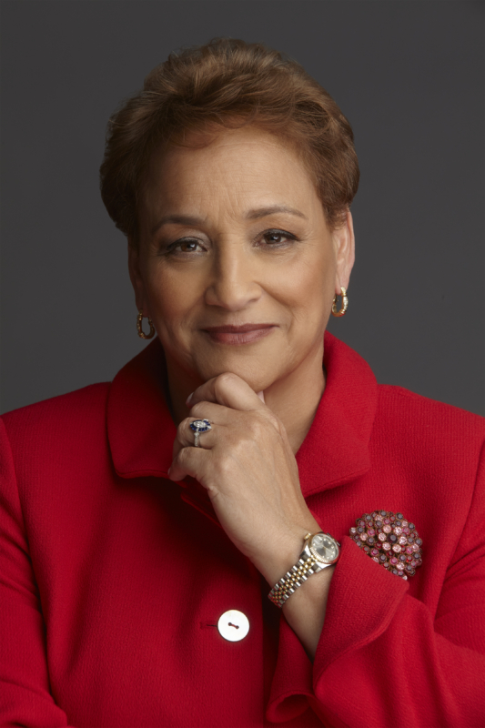 Jo Ann Jenkins, CEO of AARP, looks to camera. She is wearing a red blouse with a great broach.