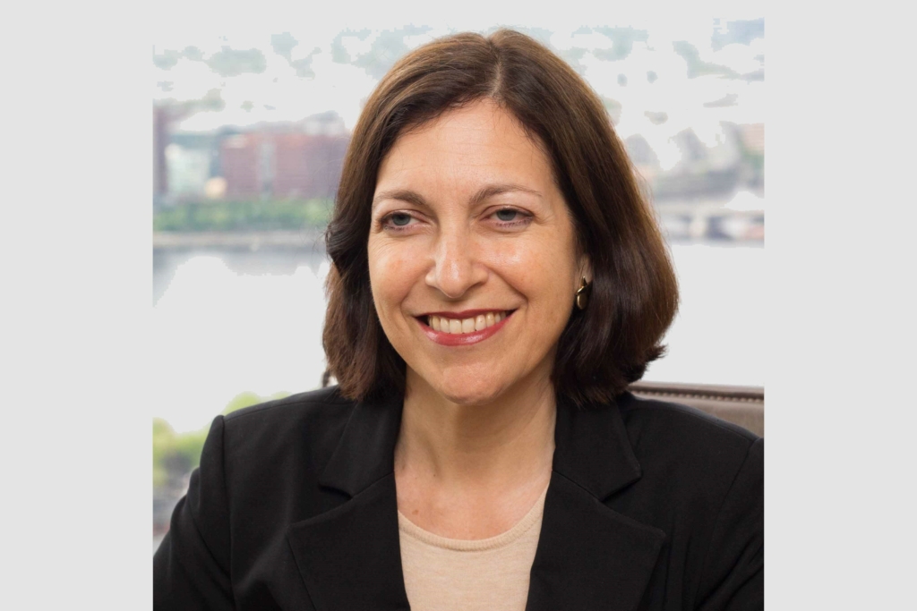 Melissa Obegi, Bain Capital's Asia General Counsel, smiles to camera, wearing a black blazer.