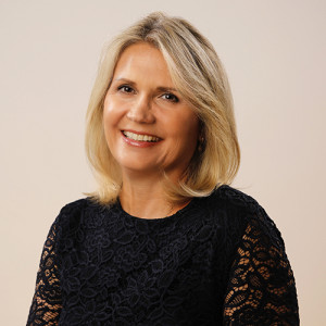 Virginie Helias, Chief Sustainability Officer at Procter & Gamble, looks to camera. She has blond hair and is wearing a black blouse.